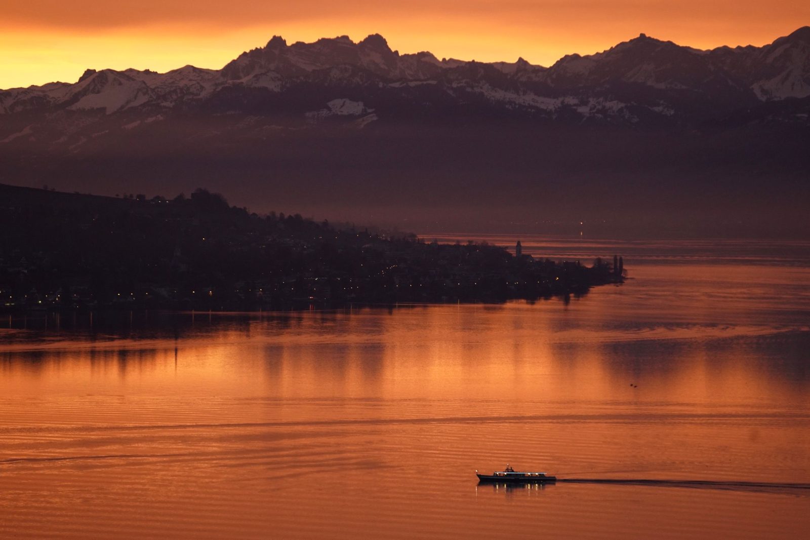 Lago con montagne nella luce della sera
