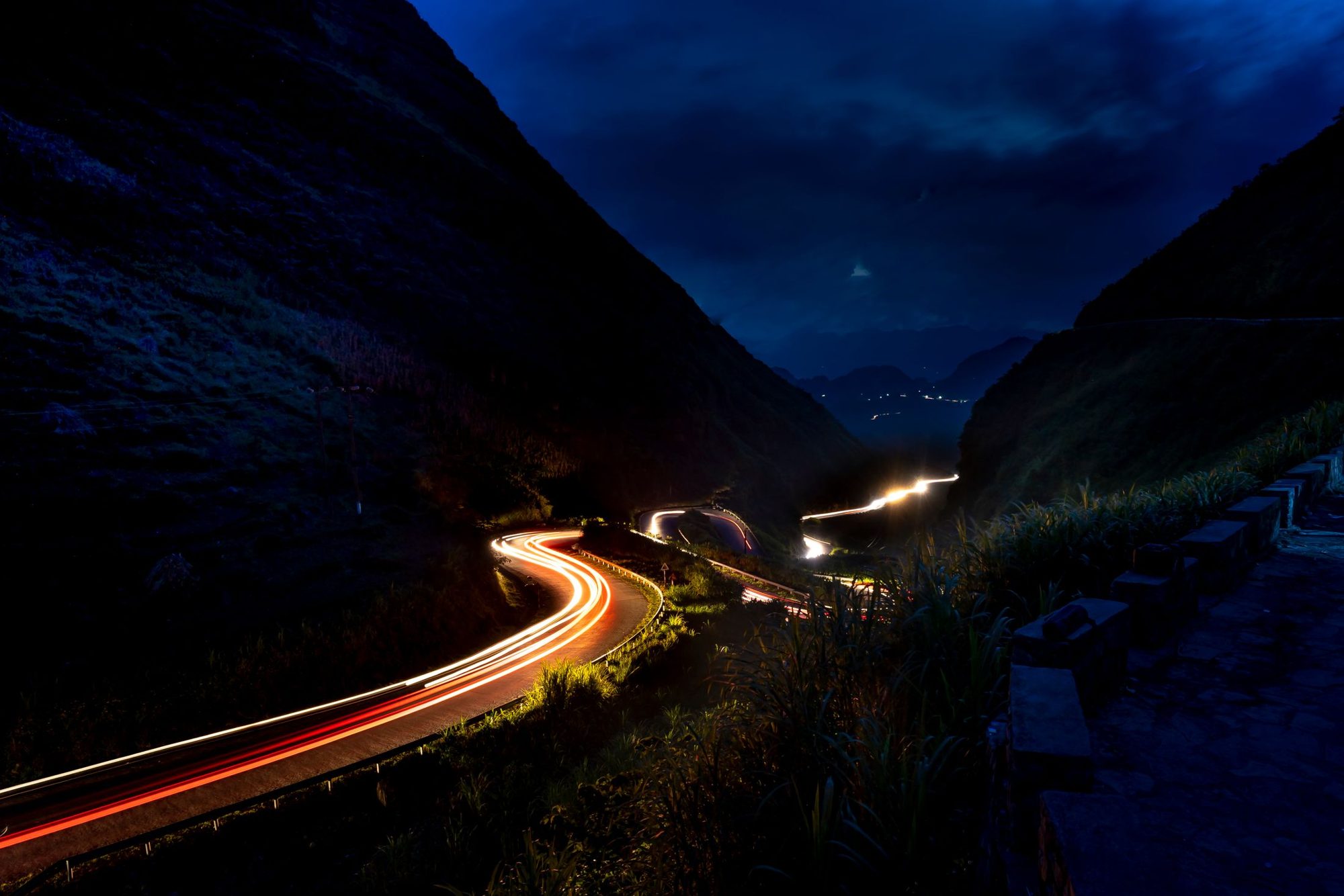 Strada di montagna con scie luminose di notte